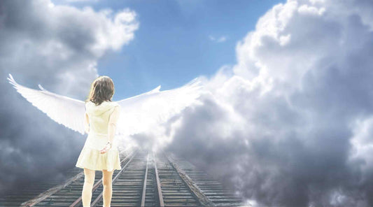 An angel on a train track looking to heaven.