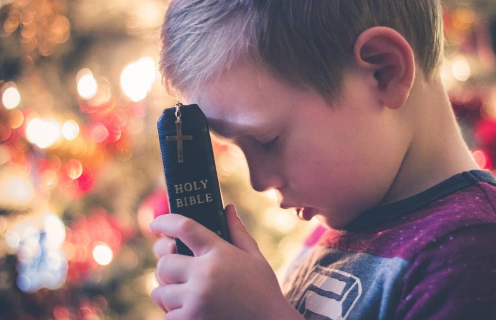 Boy holding a thinline Bible.